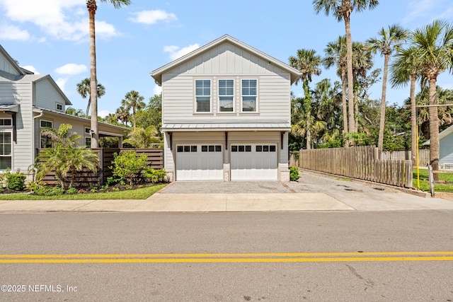 520 E Coast Dr, Atlantic Beach, FL 32233 - view of front facade featuring a garage, board and batten siding, concrete driveway, and fence