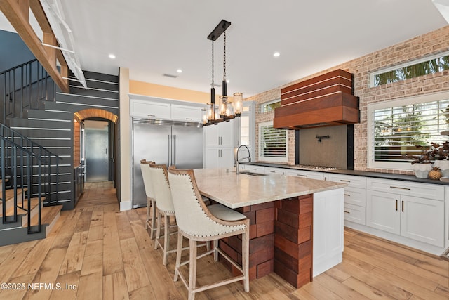 520 E Coast Dr, Atlantic Beach, FL 32233 - kitchen with a sink, arched walkways, stainless steel appliances, custom range hood, and light wood-style floors