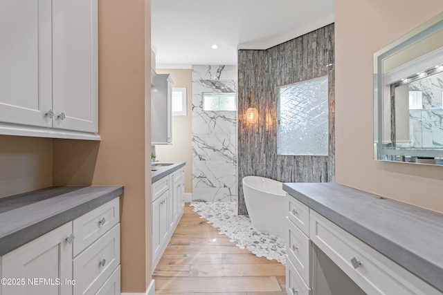 520 E Coast Dr, Atlantic Beach, FL 32233 - full bathroom featuring wood-type flooring, vanity, a freestanding bath, a marble finish shower, and recessed lighting