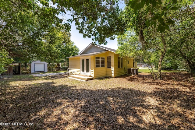 4242 Turton Ave, Jacksonville, FL 32208 - back of property with an outbuilding, a garage, french doors, and central AC