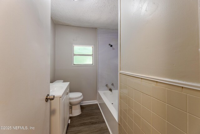 4242 Turton Ave, Jacksonville, FL 32208 - full bath featuring wood finished floors, a textured ceiling, toilet, vanity, and shower / tub combination