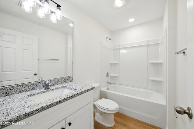 323 Rustic Rd, Satsuma, FL 32189 - full bath with toilet, wood finished floors, vanity, and washtub / shower combination