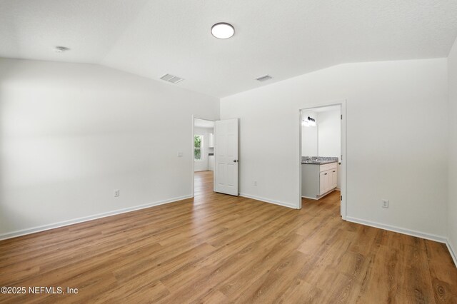 323 Rustic Rd, Satsuma, FL 32189 - unfurnished bedroom featuring lofted ceiling, light wood-style flooring, and baseboards