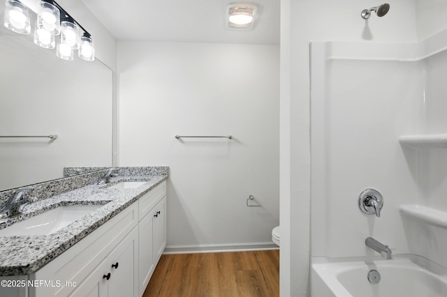 323 Rustic Rd, Satsuma, FL 32189 - full bathroom with wood finished floors, toilet, washtub / shower combination, double vanity, and baseboards