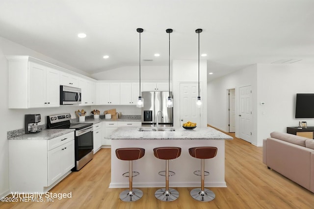 323 Rustic Rd, Satsuma, FL 32189 - kitchen featuring stainless steel appliances, light wood-style floors, a breakfast bar, white cabinetry, and a kitchen island with sink