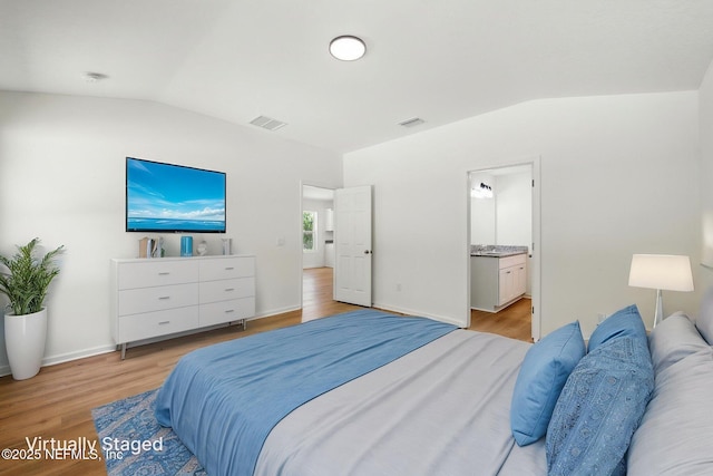 323 Rustic Rd, Satsuma, FL 32189 - bedroom featuring lofted ceiling, light wood finished floors, and ensuite bath
