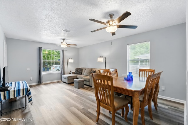 1961 Spring Drive Rd, Jacksonville, FL 32209 - dining space featuring a textured ceiling, light wood-style flooring, a ceiling fan, and baseboards