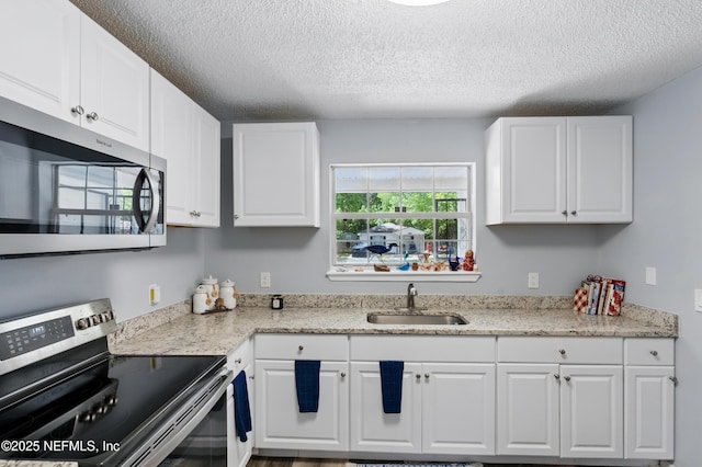 1961 Spring Drive Rd, Jacksonville, FL 32209 - kitchen with stainless steel appliances, a sink, a textured ceiling, white cabinets, and light stone countertops