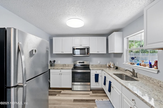 1961 Spring Drive Rd, Jacksonville, FL 32209 - kitchen featuring stainless steel appliances, a sink, a textured ceiling, and white cabinets
