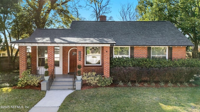 3712 Trask St, Jacksonville, FL 32205 - view of front of home featuring brick siding, a front lawn, a chimney, a porch, and roof with shingles