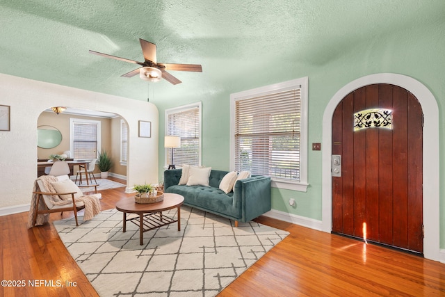 3712 Trask St, Jacksonville, FL 32205 - living area featuring arched walkways, ceiling fan, light wood-type flooring, a textured ceiling, and baseboards
