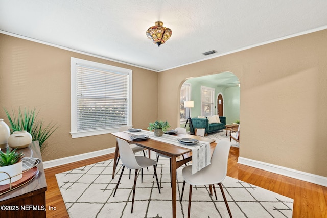 3712 Trask St, Jacksonville, FL 32205 - dining room featuring arched walkways, baseboards, wood finished floors, and crown molding
