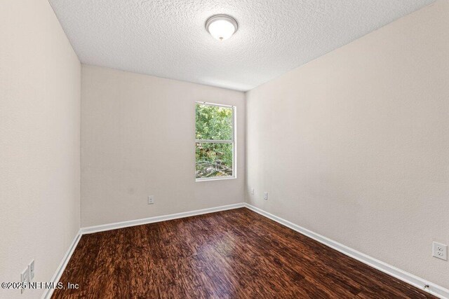 3143 Post St, Jacksonville, FL 32205 - empty room featuring dark wood finished floors, a textured ceiling, and baseboards