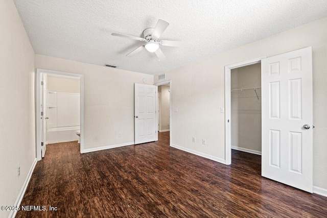 3143 Post St, Jacksonville, FL 32205 - unfurnished bedroom featuring wood finished floors, a textured ceiling, a walk in closet, a closet, and baseboards