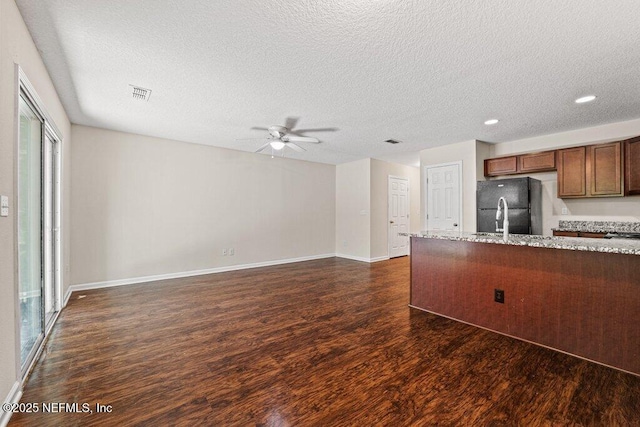 3143 Post St, Jacksonville, FL 32205 - kitchen featuring dark wood-type flooring, freestanding refrigerator, a ceiling fan, a textured ceiling, and light stone countertops