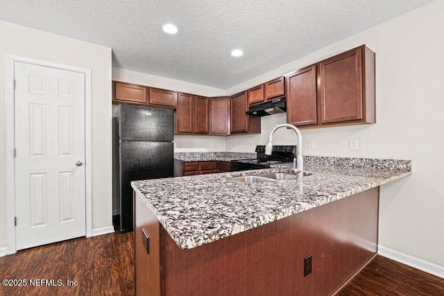 3143 Post St, Jacksonville, FL 32205 - kitchen featuring black appliances, under cabinet range hood, a peninsula, baseboards, and dark wood finished floors