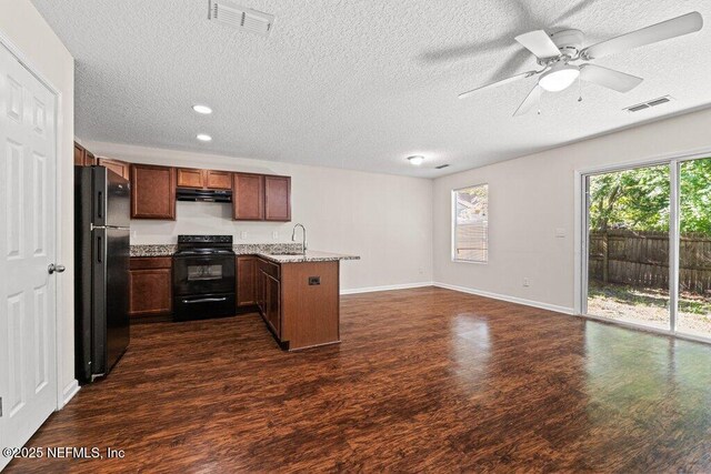 3143 Post St, Jacksonville, FL 32205 - kitchen featuring black appliances, a sink, a peninsula, dark wood-style flooring, and a textured ceiling