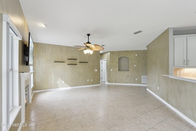 1726 Chatham Village Dr, Fleming Island, FL 32003 - unfurnished living room featuring a ceiling fan, light tile patterned flooring, a glass covered fireplace, and baseboards