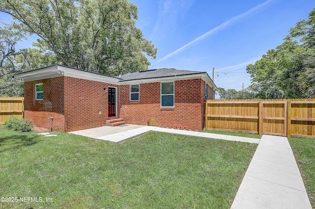 8198 Paul Jones Dr, Jacksonville, FL 32208 - rear view of property featuring entry steps, brick siding, and a patio area