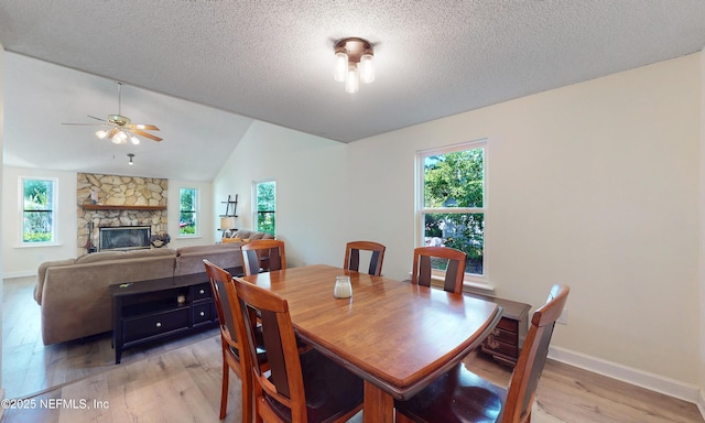 5325 Julington Ridge Dr S, Jacksonville, FL 32258 - dining room with light wood-style floors, lofted ceiling, a stone fireplace, ceiling fan, and baseboards
