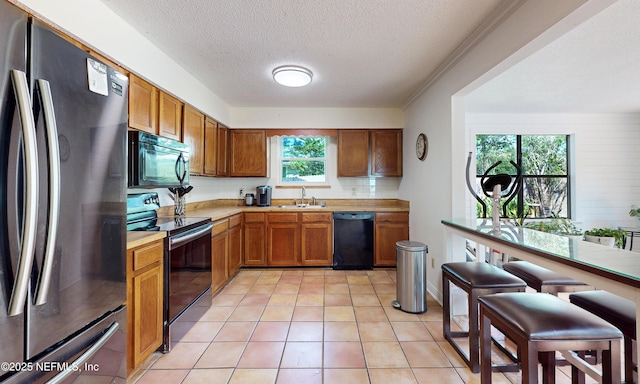 5325 Julington Ridge Dr S, Jacksonville, FL 32258 - kitchen featuring black appliances, a sink, light countertops, a textured ceiling, and brown cabinets