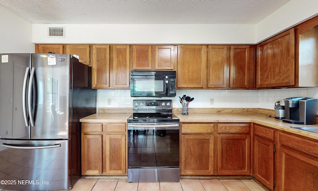 5325 Julington Ridge Dr S, Jacksonville, FL 32258 - kitchen featuring appliances with stainless steel finishes, light countertops, brown cabinets, and a textured ceiling