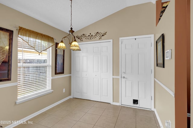 1695 Northglen Cir, Middleburg, FL 32068 - unfurnished dining area with vaulted ceiling, light tile patterned floors, a textured ceiling, and baseboards