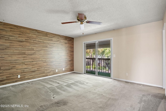 695 A1A N Unit 123, Ponte Vedra Beach, FL 32082 - empty room with ceiling fan, baseboards, wooden walls, a textured ceiling, and carpet