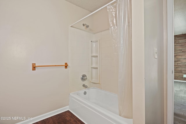 695 A1A N Unit 123, Ponte Vedra Beach, FL 32082 - bathroom with baseboards, shower / bath combo, wood finished floors, and a textured ceiling