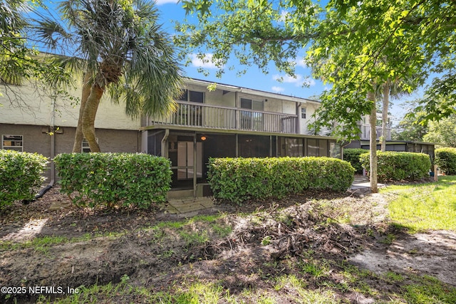 695 A1A N Unit 123, Ponte Vedra Beach, FL 32082 - back of house with a sunroom, a balcony, and stucco siding