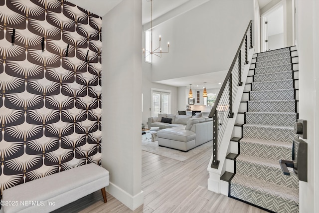 338 Magnolia St, Atlantic Beach, FL 32233 - staircase with a chandelier, wood finished floors, a high ceiling, and baseboards