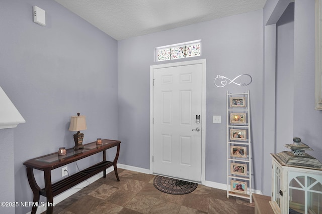 137 Codman Dr, Saint Augustine, FL 32084 - foyer with a textured ceiling, baseboards, and dark stone finish floors