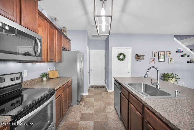 137 Codman Dr, Saint Augustine, FL 32084 - kitchen with appliances with stainless steel finishes, a sink, stone finish flooring, baseboards, and brown cabinetry