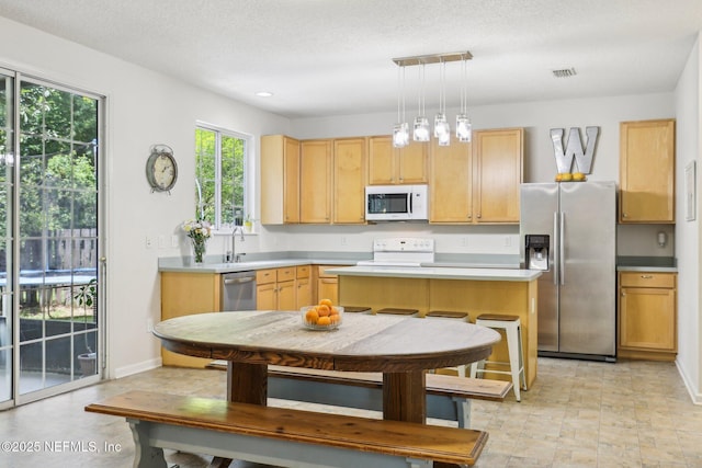 864 Collinswood Dr W, Jacksonville, FL 32225 - kitchen featuring stainless steel appliances, a kitchen island, light countertops, and baseboards
