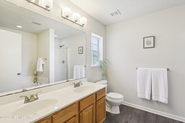 864 Collinswood Dr W, Jacksonville, FL 32225 - full bath with a shower with shower door, a textured ceiling, double vanity, wood finished floors, and toilet