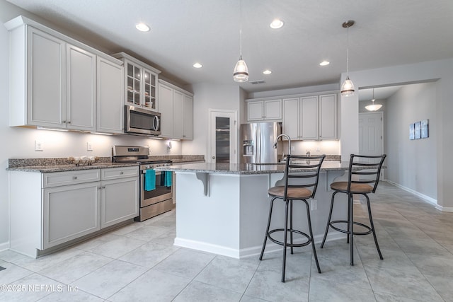 497 Convex Ln, Saint Augustine, FL 32095 - kitchen featuring appliances with stainless steel finishes, recessed lighting, a center island with sink, dark stone counters, and a kitchen breakfast bar