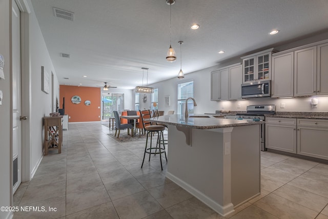 497 Convex Ln, Saint Augustine, FL 32095 - kitchen with stainless steel appliances, a sink, a ceiling fan, a kitchen island with sink, and recessed lighting