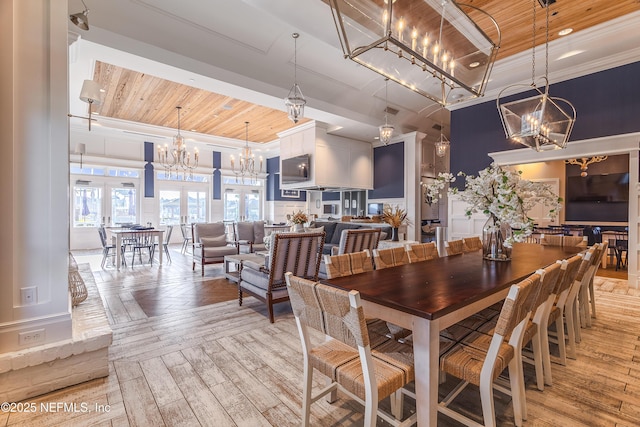 497 Convex Ln, Saint Augustine, FL 32095 - dining space featuring a chandelier, wooden ceiling, crown molding, light wood-type flooring, and a raised ceiling