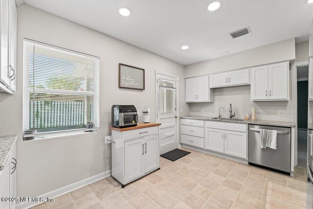 6500 Altama Rd, Jacksonville, FL 32216 - kitchen featuring dishwasher, a sink, white cabinets, light stone counters, and recessed lighting