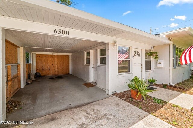 6500 Altama Rd, Jacksonville, FL 32216 - property entrance with concrete block siding, a carport, and concrete driveway