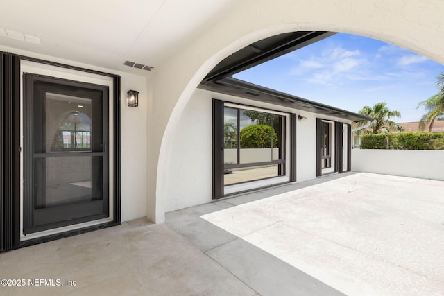 13 Clarendon Ct S, Palm Coast, FL 32137 - doorway to property featuring stucco siding and a patio area