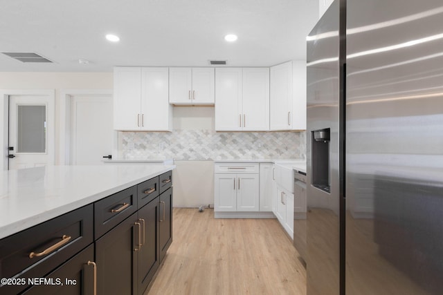 13 Clarendon Ct S, Palm Coast, FL 32137 - kitchen featuring stainless steel refrigerator with ice dispenser, white cabinetry, light wood-type flooring, backsplash, and recessed lighting