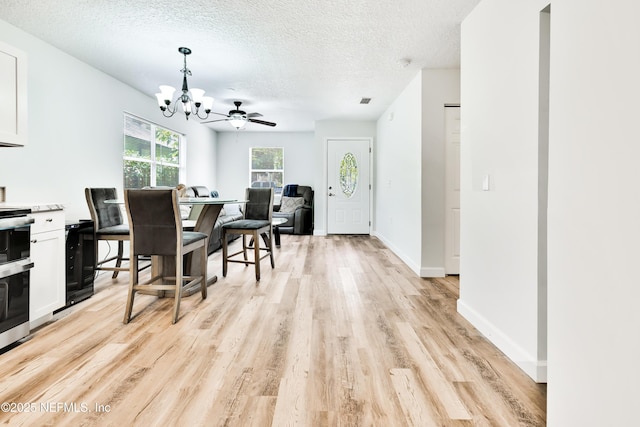 159 Twine St, Saint Augustine, FL 32084 - dining room featuring a chandelier, light wood-type flooring, a textured ceiling, and baseboards