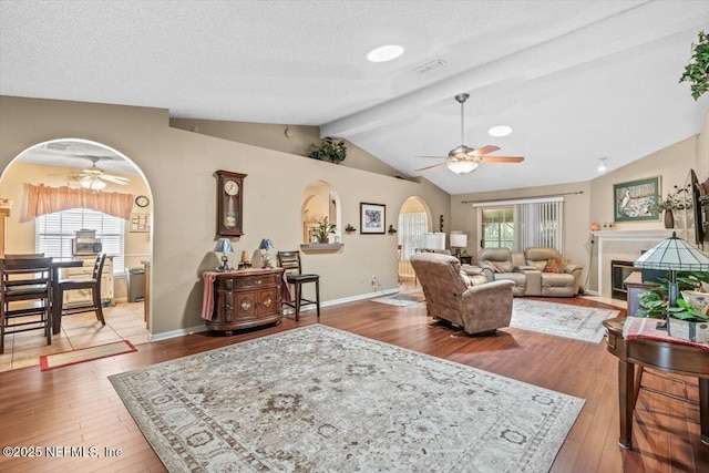 1275 Pirates Cove Ln, Fleming Island, FL 32003 - living area with a ceiling fan, arched walkways, wood-type flooring, lofted ceiling, and baseboards