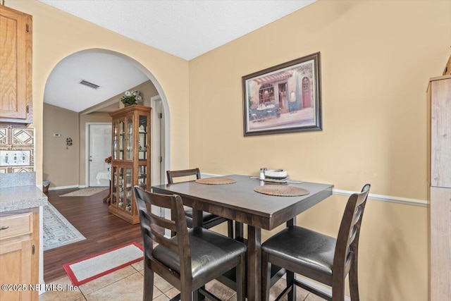 1275 Pirates Cove Ln, Fleming Island, FL 32003 - dining space featuring arched walkways, dark wood-style floors, and baseboards
