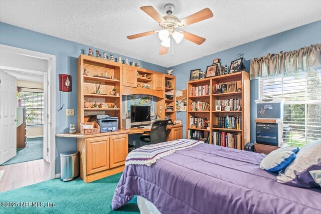 1275 Pirates Cove Ln, Fleming Island, FL 32003 - bedroom with a textured ceiling, an office area, light colored carpet, and a ceiling fan