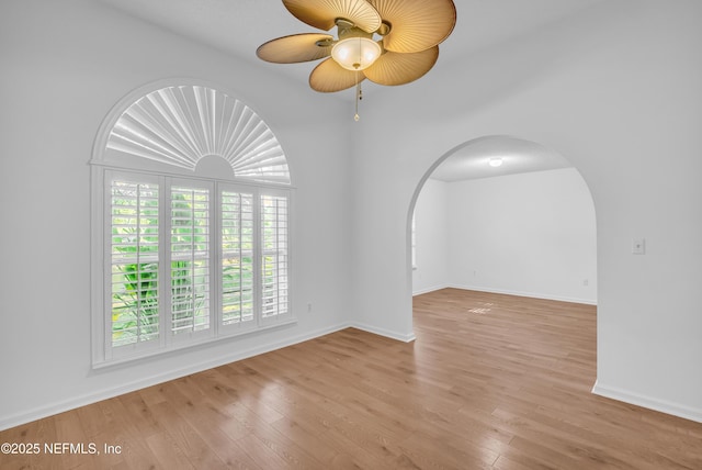 96428 Chester Rd, Yulee, FL 32097 - unfurnished room with arched walkways, a ceiling fan, light wood-type flooring, and baseboards