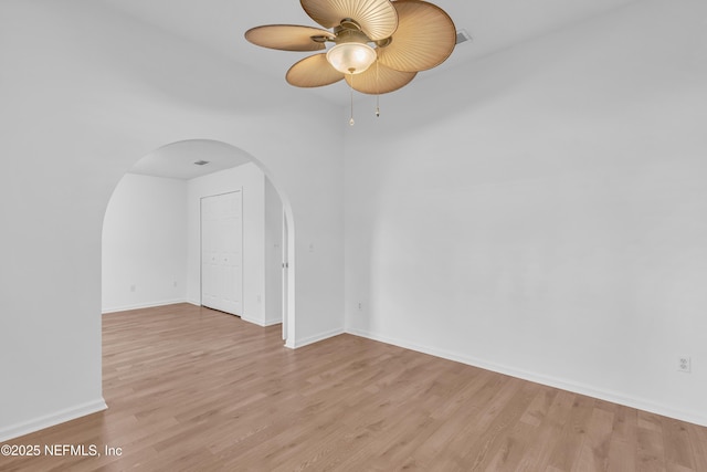 96428 Chester Rd, Yulee, FL 32097 - empty room featuring arched walkways, light wood finished floors, a ceiling fan, and baseboards