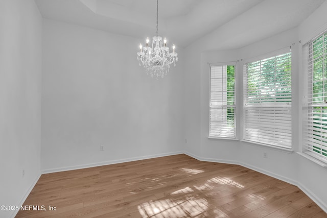 96428 Chester Rd, Yulee, FL 32097 - empty room featuring a chandelier, hardwood / wood-style flooring, baseboards, and lofted ceiling