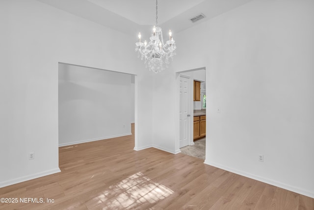 96428 Chester Rd, Yulee, FL 32097 - empty room featuring a chandelier, light wood finished floors, baseboards, and a high ceiling